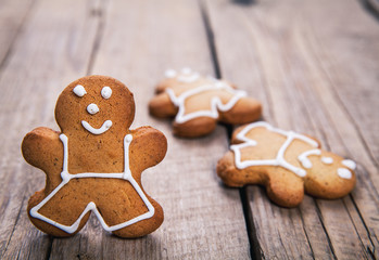 HIgh angle view of three gingerbread men on a rustic white kitch