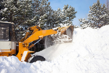 Wheel loader is cleaning a road from snow