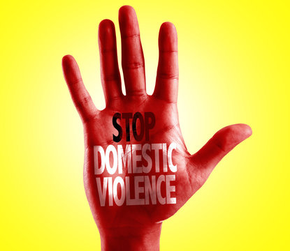 Stop Domestic Violence written on hand with yellow background