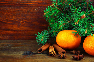 tangerines and fir-tree branches on wooden background