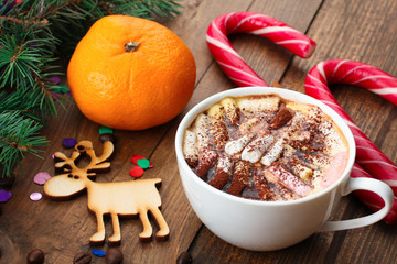 tangerines and fir-tree branches with Christmas candy and a Cup of coffee on wooden background