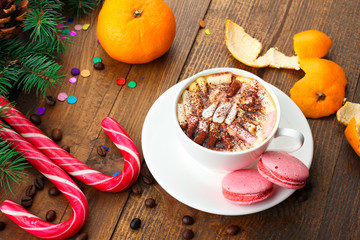 tangerines and fir-tree branches cone and Christmas candy and cookies and a Cup of coffee on wooden background