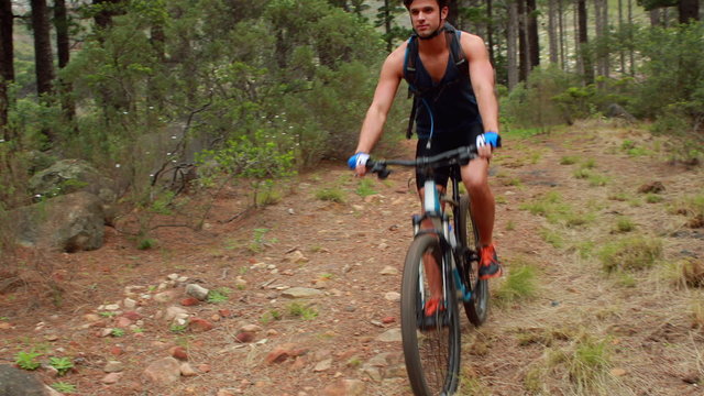 Man biking through a forest 