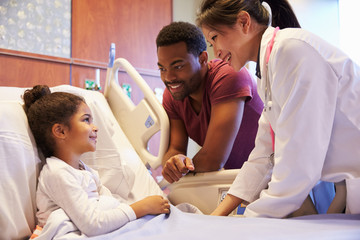 Pediatrician Visiting Father And Child In Hospital Bed