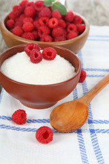 Raspberries in a bowl and sugar.
