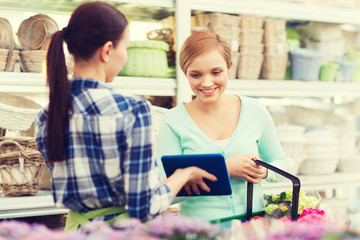 happy women with tablet pc at flower shop