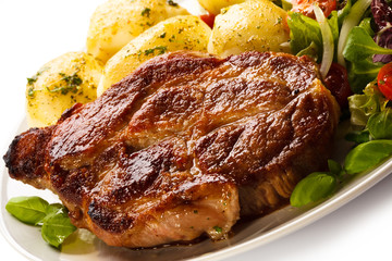 Grilled steaks, boiled potatoes and vegetable salad 