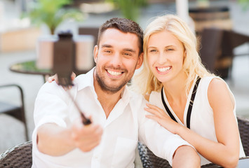 Fototapeta premium happy couple taking selfie with smartphone at cafe