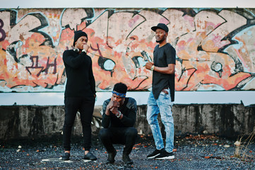 Three rap singers band on the roof background graffiti wall
