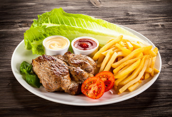 Grilled steak, French fries and vegetables 