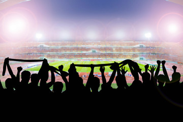 Silhouettes of soccer supporters in stadium during match