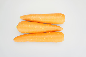 Fresh orange carrots put arrange on a white table