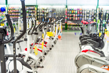 Store selling sports goods. Treadmills exercise machines stand in rows.