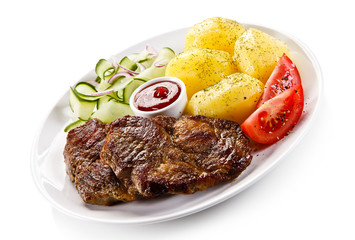 Grilled steaks, boiled potatoes and vegetable salad 