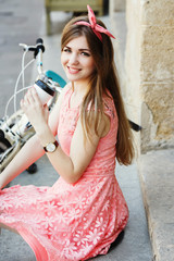  blond-brown girl sitting on stairs with a cup of coffee