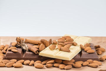 Close-up of still life: white and dark chocolate, almonds, cinna