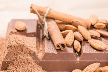 Close-up of still life: white and dark chocolate, almonds, cinna