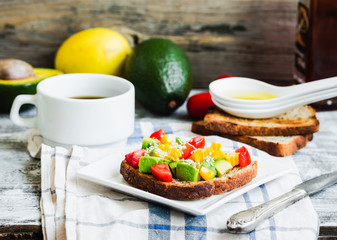 toast with fresh avocado, tomato and corn, a cup of coffee, brea