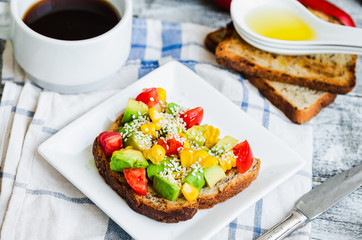 toast with fresh avocado, tomato and corn, a cup of coffee, brea