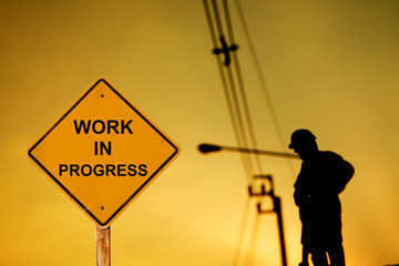 warning sign message "WORK IN PROGRESS" with silhouette of construction worker.
