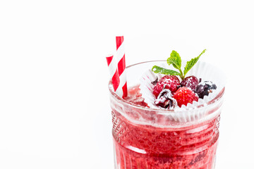 Pink wine drink with berries and striped straws for a cocktail. The upper part of the glass. White background. Winter refreshments