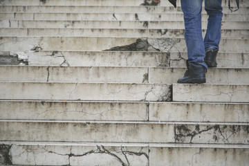 Man walking climb up in old stairs