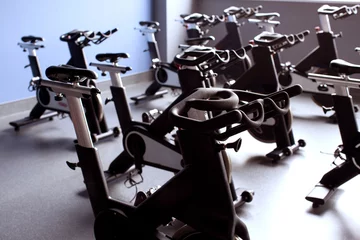 Velvet curtains Bicycles A row of black exercise bikes in a bright large gym room