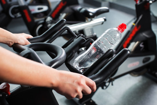 Cropped image of woman's hands holding exercise bike