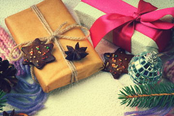 Christmas gift boxes, cookies, disco ball, fir tree branch and winter scarf