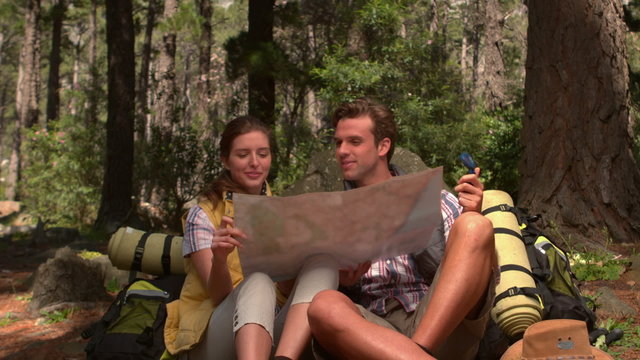 Smiling couple with map on a hike in the countryside