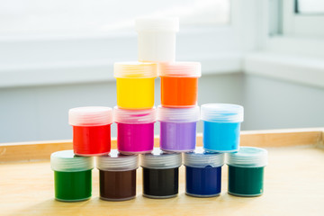 Баночки с акриловой краской стоят друг на друге в...