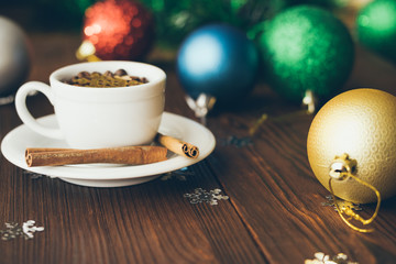 Cup and saucer on a wooden table among Christmas decorations