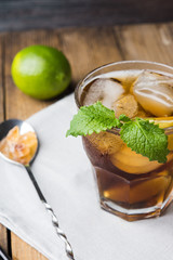 Cuba libre with lime on black wooden table