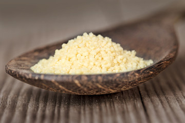 close up of cous-cous in a wooden spoon