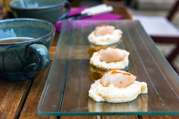 Close up of pan seared sea scallops and a cup of cider