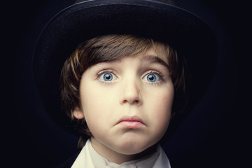 Close up portrait of a sad boy in black hat