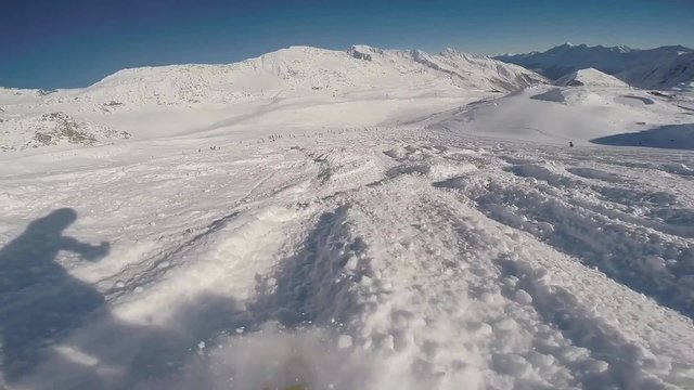 Snowboarding downhill through fresh powder snow