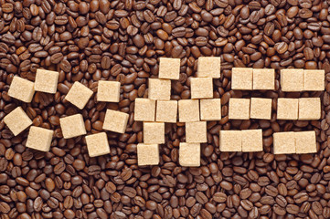 Word coffee written by cane sugar over scattered coffee beans