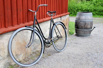 Obraz premium Vélo suédois noir posé sur un mur devant un tonneau en bois