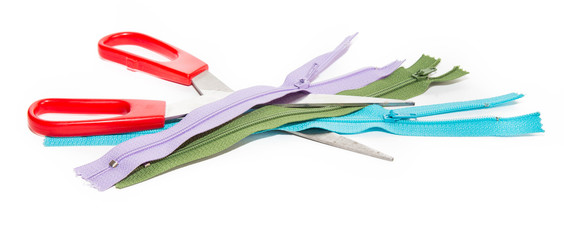 Obraz na płótnie Canvas Scissors and three color zippers on a white background