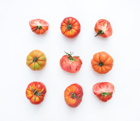  Selection of heirloom tomatoes on a white backdrop.