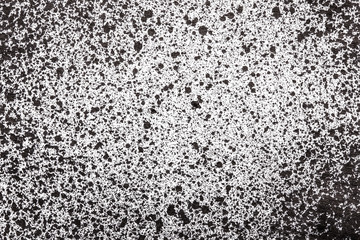 Black ink splashes on white paper texture.