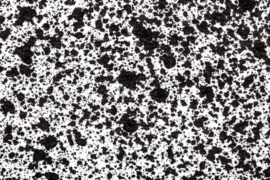 Black ink splashes on white paper texture. © Paweł Michałowski
