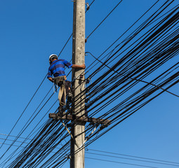 electrician working  on electric power pole 