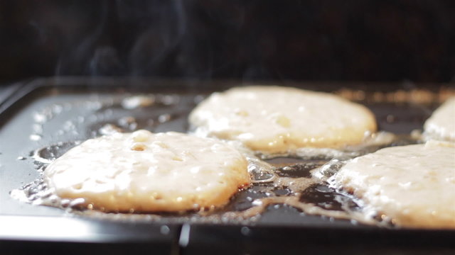 Closeup of home made apple pancakes cooking on an electric griddle