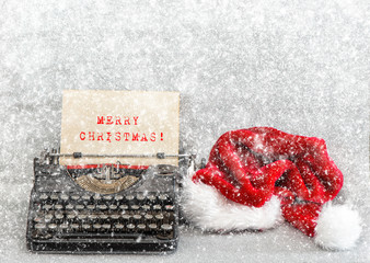 Old typewriter red hat Merry Christmas. Retro style picture