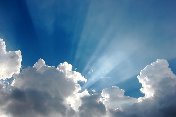 colorful blue sky with tiny clouds and sun rays