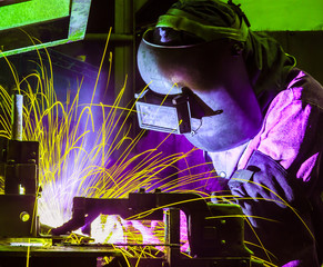 worker with protective mask welding metal