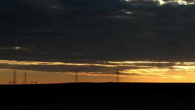 Sun Emerges from Clouds over Powerlines