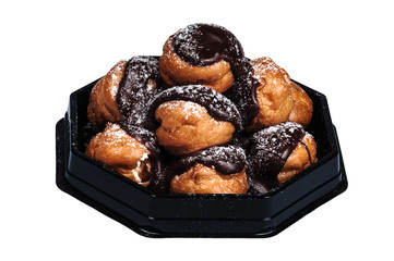 Profiteroles in a heap rich Belgian chocolate white background